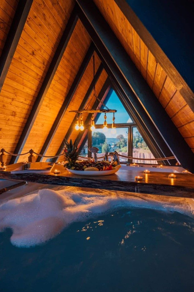 A-frame tiny house iç mekân — jakuzi ve üçgen pencere