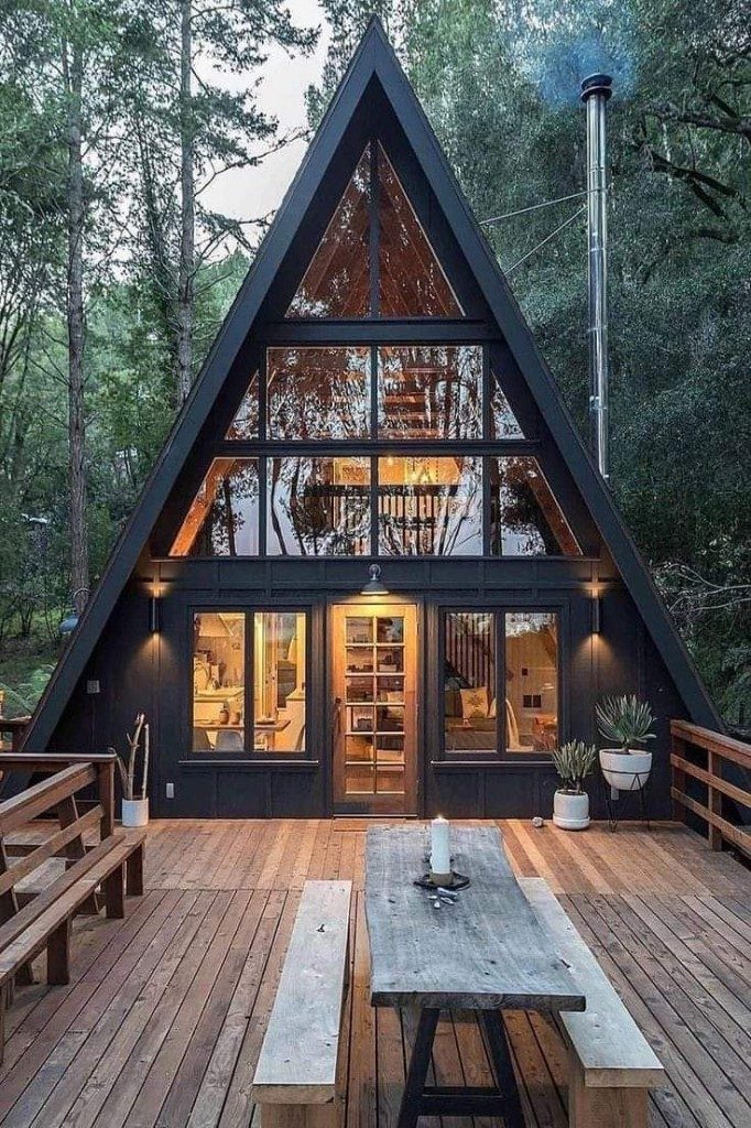 Siyah A-frame tiny house — cam cephe ve orman terası